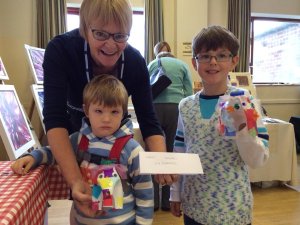 Babs Robinson, providing some creative support to children making milk carton elephants at Kegworth Craft and Gift Fayre